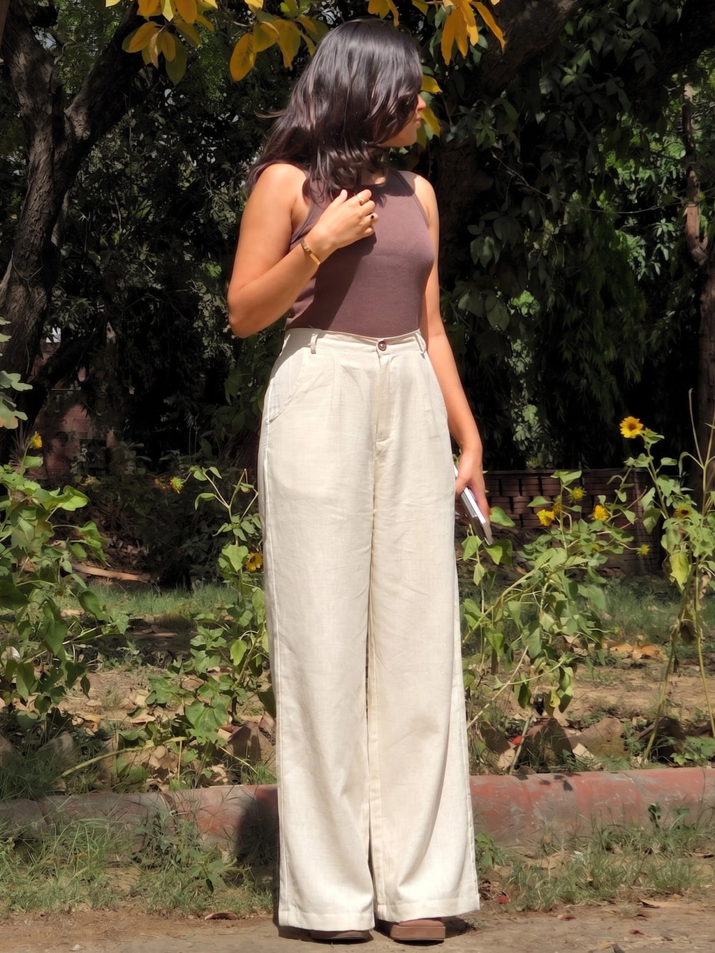 Side angle of flowing wide leg beige cotton linen trousers showing the relaxed, loose fit.