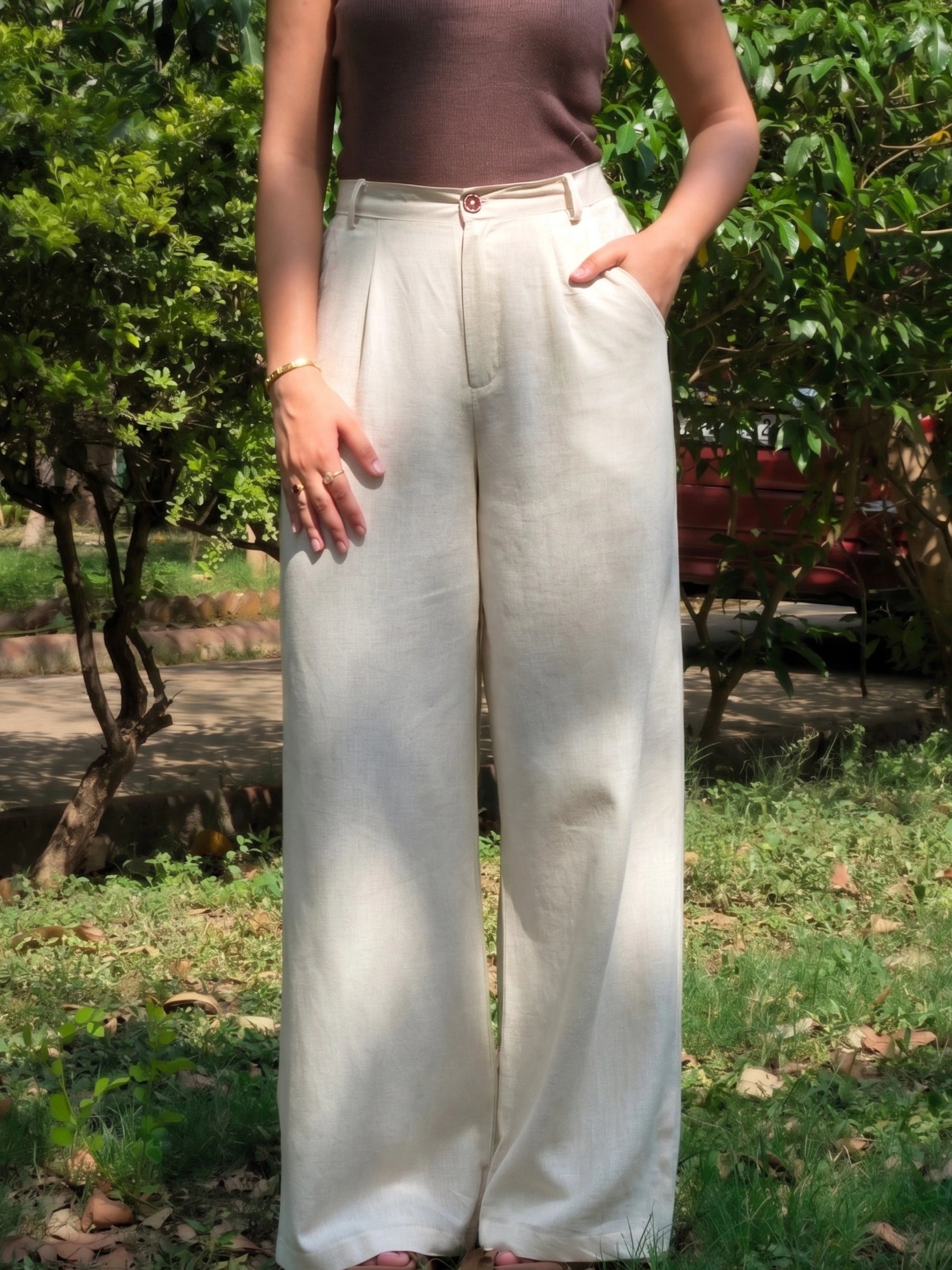 ide pocket detail on loose fitted beige trousers showcasing functional pockets that fit a phone.