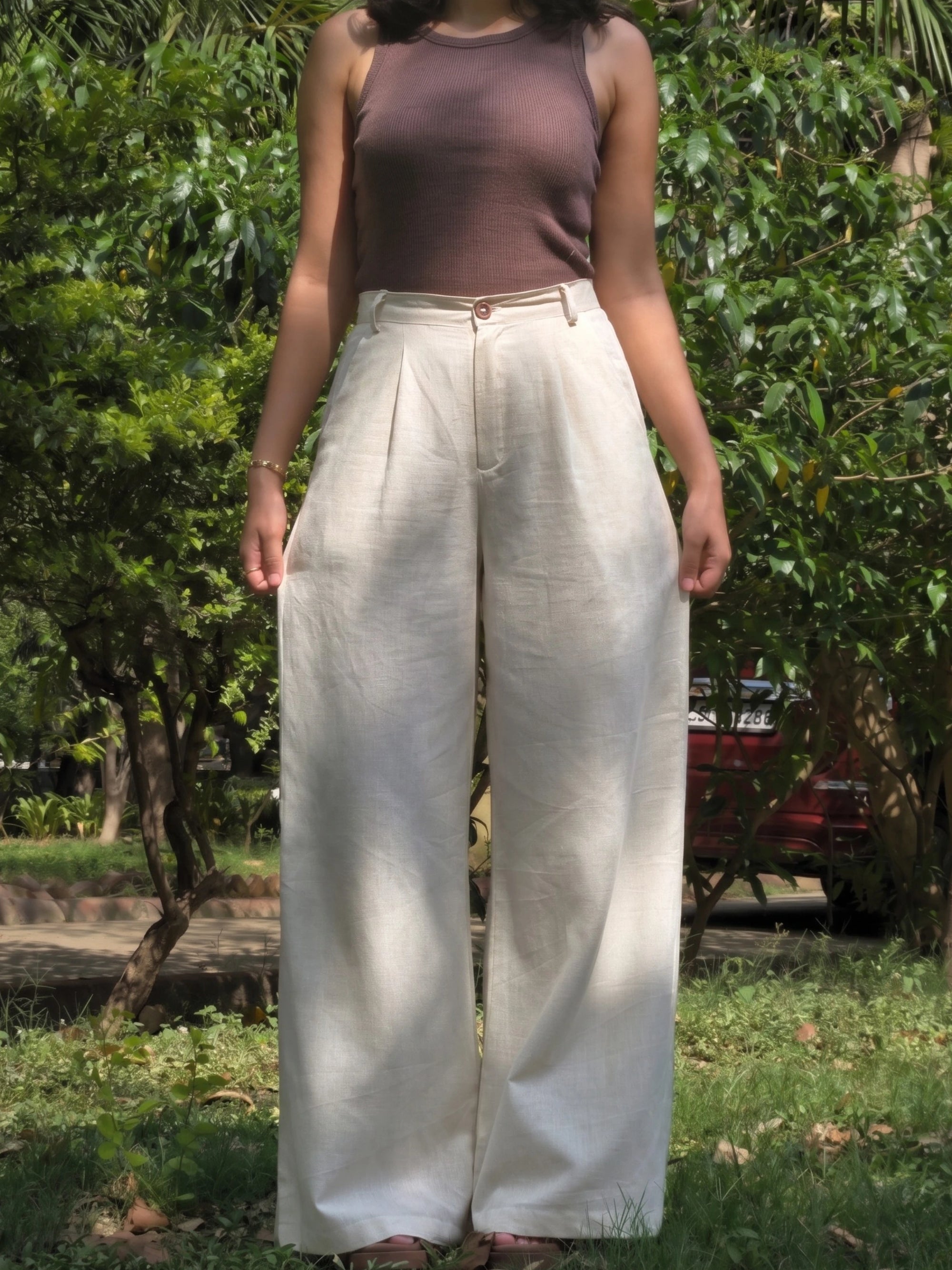 Model walking in lightweight, breathable wide leg beige cotton pants showing fabric movement.