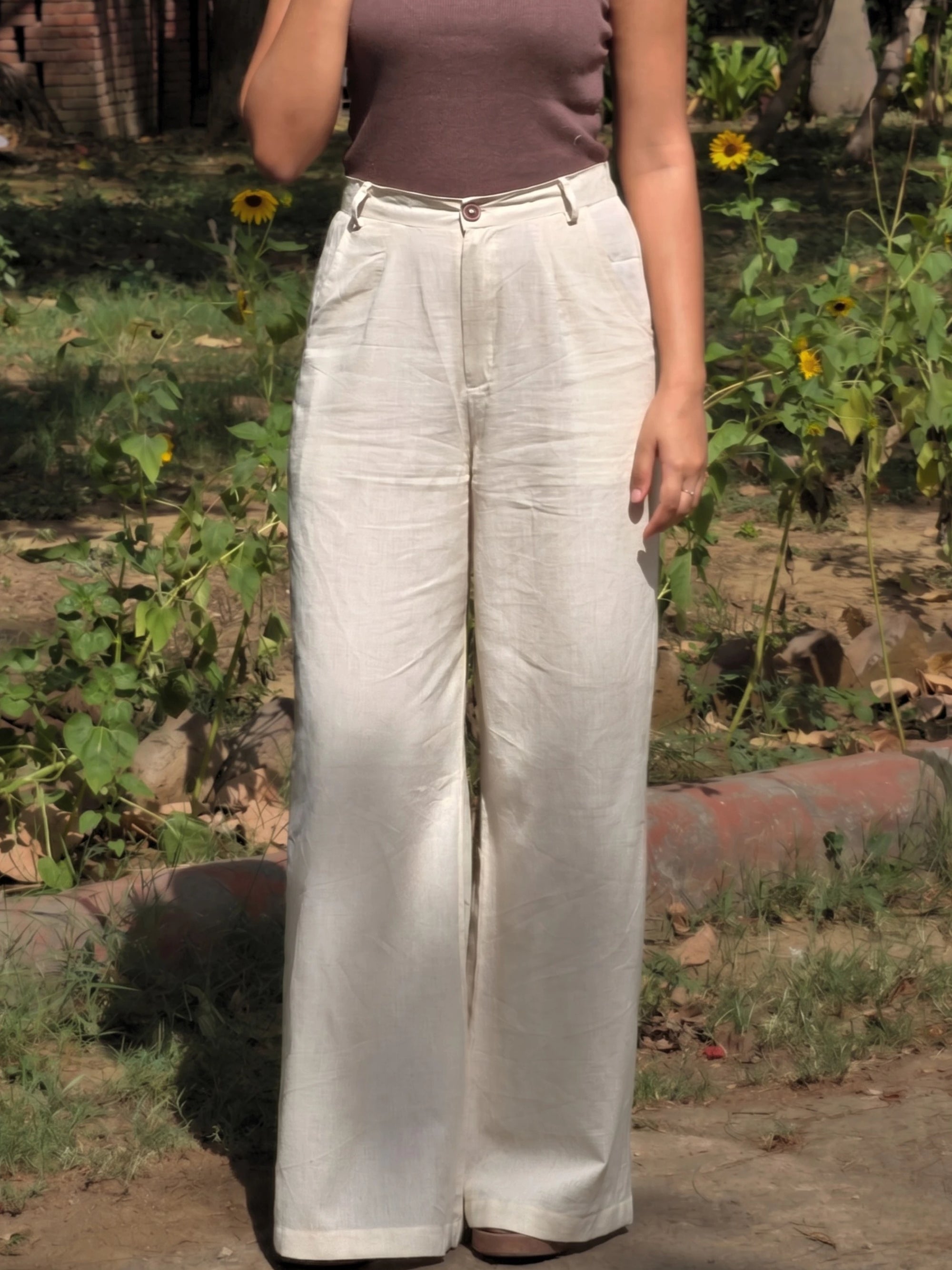 Front view of women wearing high waisted Beige Loose Fitted Cotton Pants with a tucked-in top.