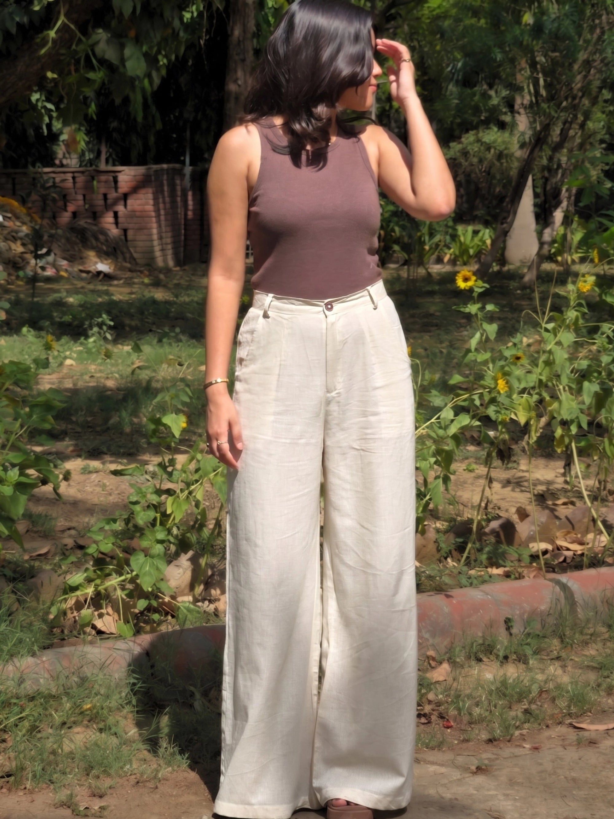 Professional office outfit featuring high waisted beige linen trousers and a structured shirt.