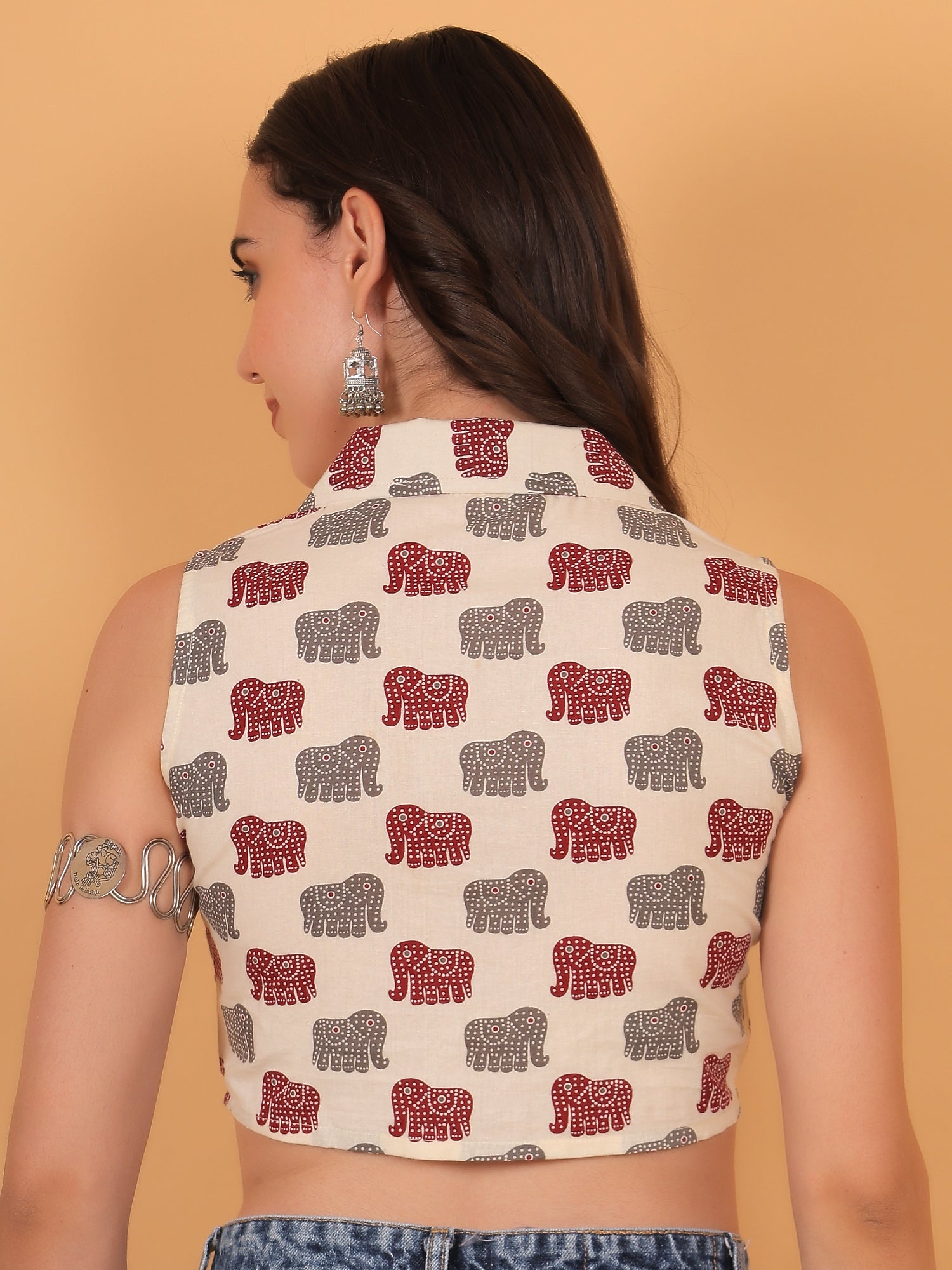 Back view of fitted white sleeveless crop top showing scattered elephant motifs