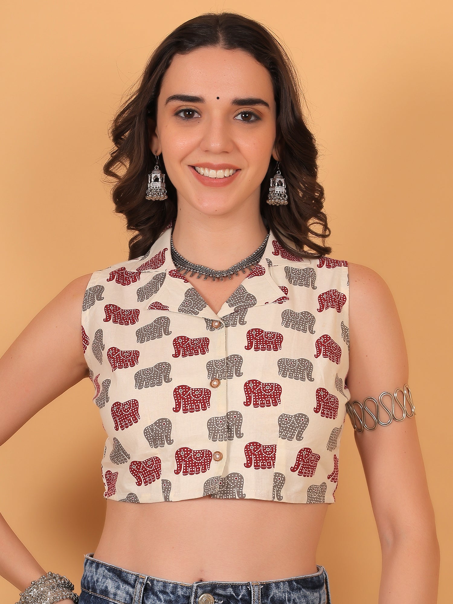 Model smiling in Airavat white sleeveless crop shirt with red and grey elephant print
