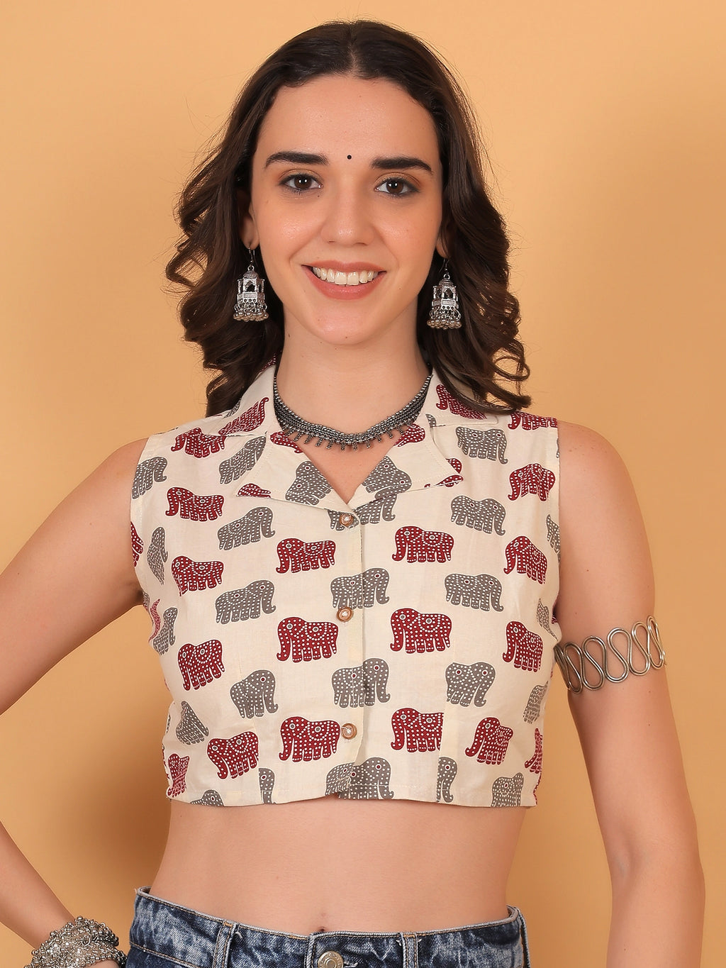 Front view fit inspo of a women white sleeveless crop shirt featuring a regular collar and a bold red airavat elephant print pattern.