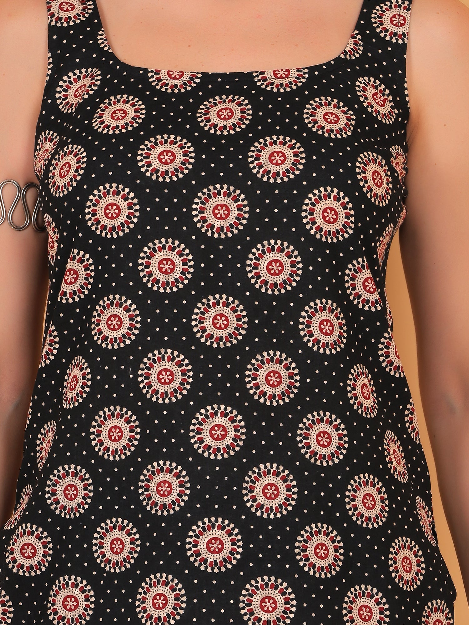 Close up of traditional Ajrakh-style circular geometric print on black fabric.