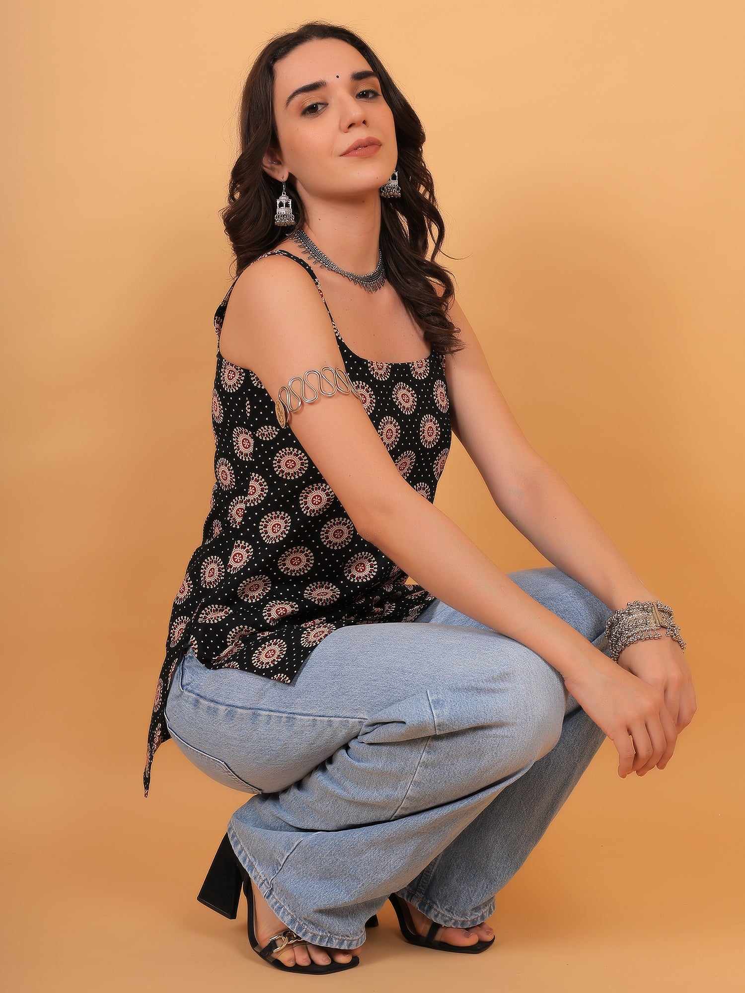College girl wearing casual black ethnic top with silver arm cuff accessory.
