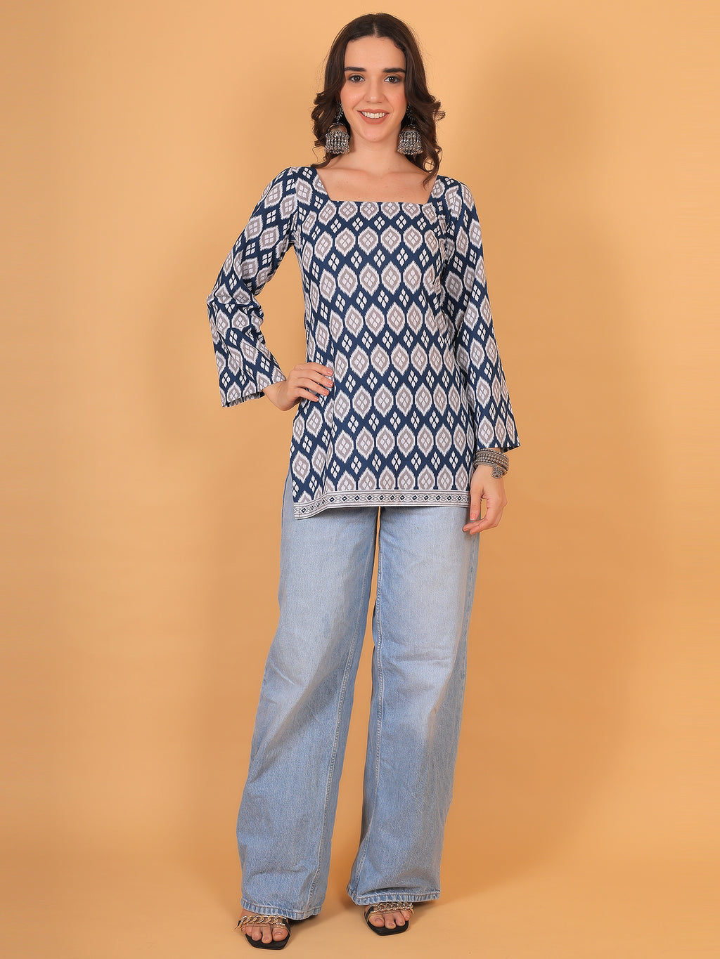 Model wearing blue geometric print short kurti paired with wide-leg denim jeans