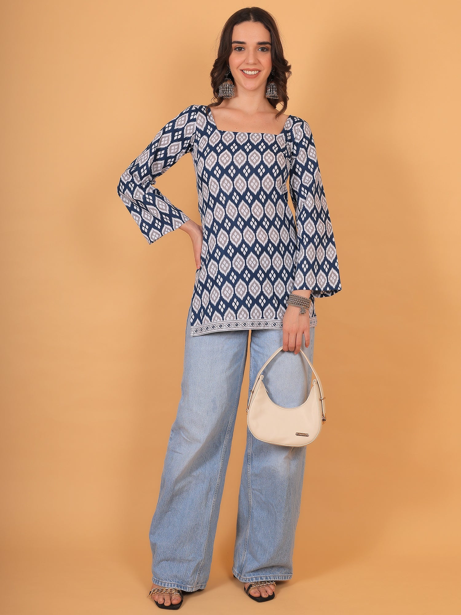 Model wearing blue geometric print short kurti paired with wide-leg denim jeans