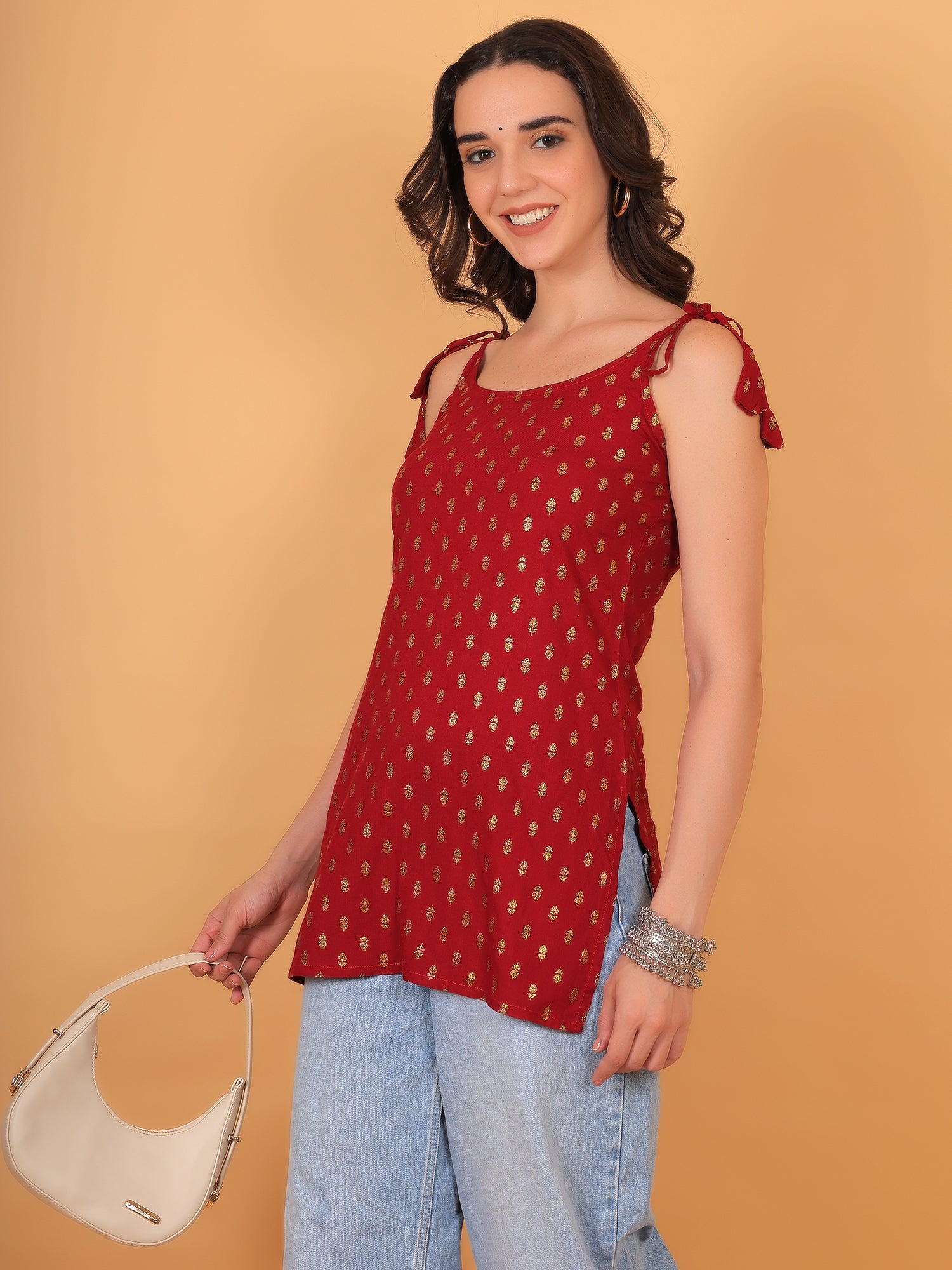 Close up of gold foil print pattern on red rayon fabric party wear top.