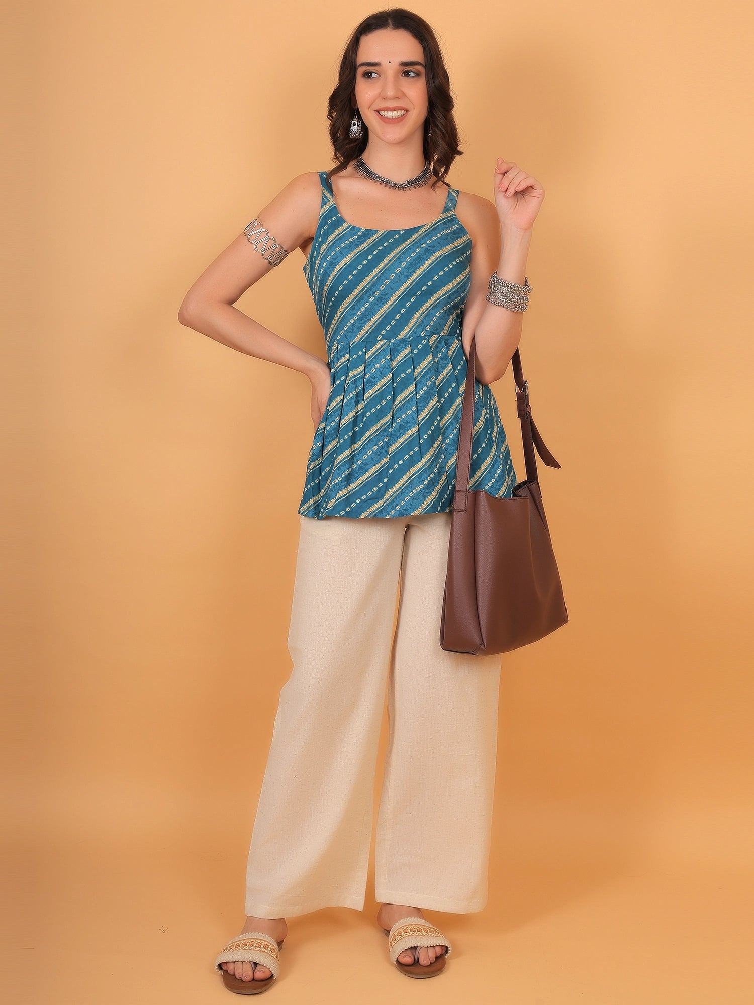 Desi fusion look featuring a printed sleeveless short kurti with beige trousers and silver choker jewelry, ideal for Rakshabandhan or festive wear.