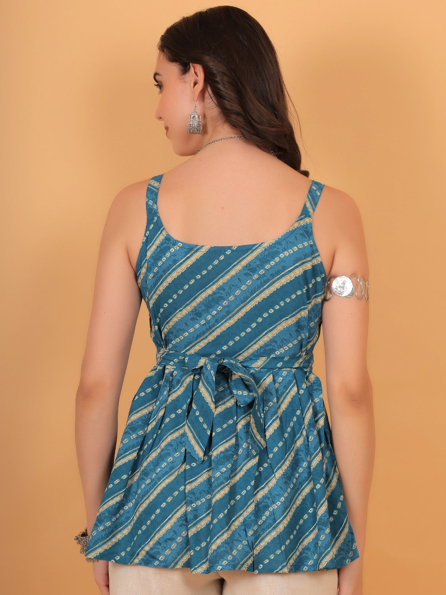 Back design of a fit and flare short kurti top showcasing the adjustable single dori fitted back tie up bow silhouette.