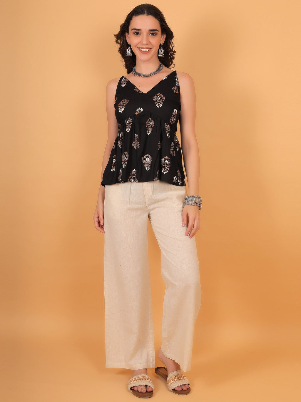 Black and golden print kurti top paired with ethnic accessories, perfect for college or office wear.