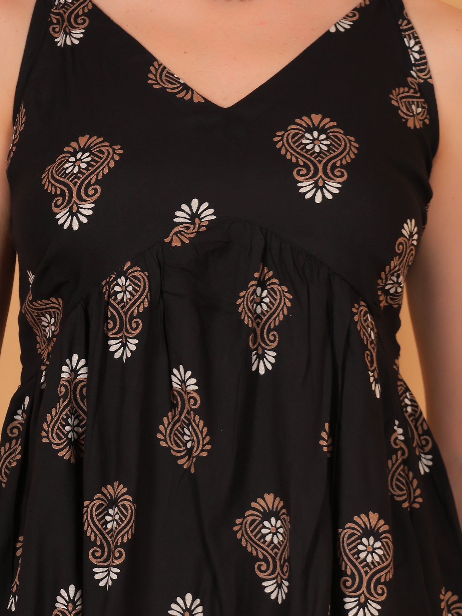 Black sleeveless top with intricate white and brown patterns 
