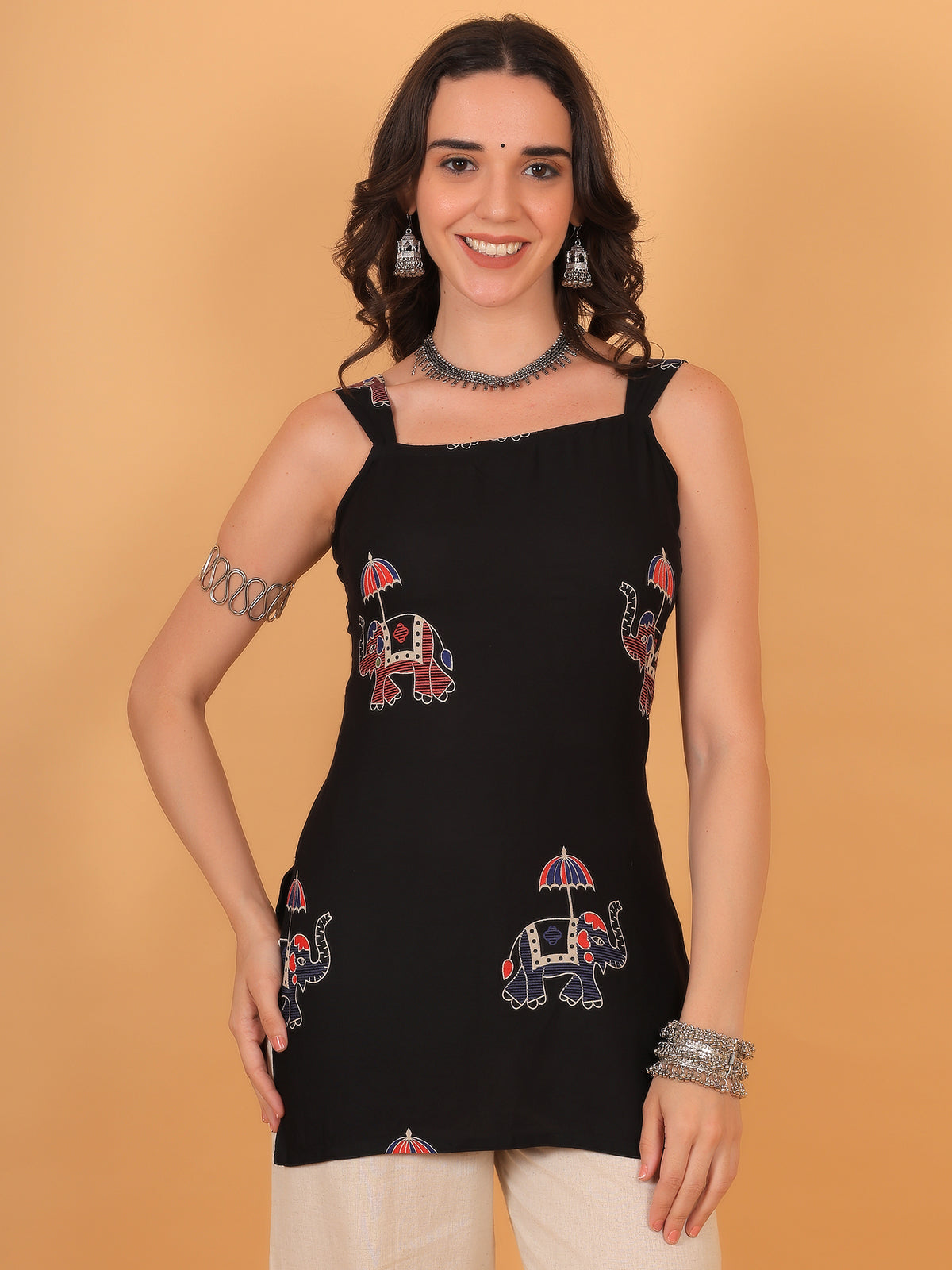 Model smiling in black sleeveless kurti with red and blue elephant print motifs