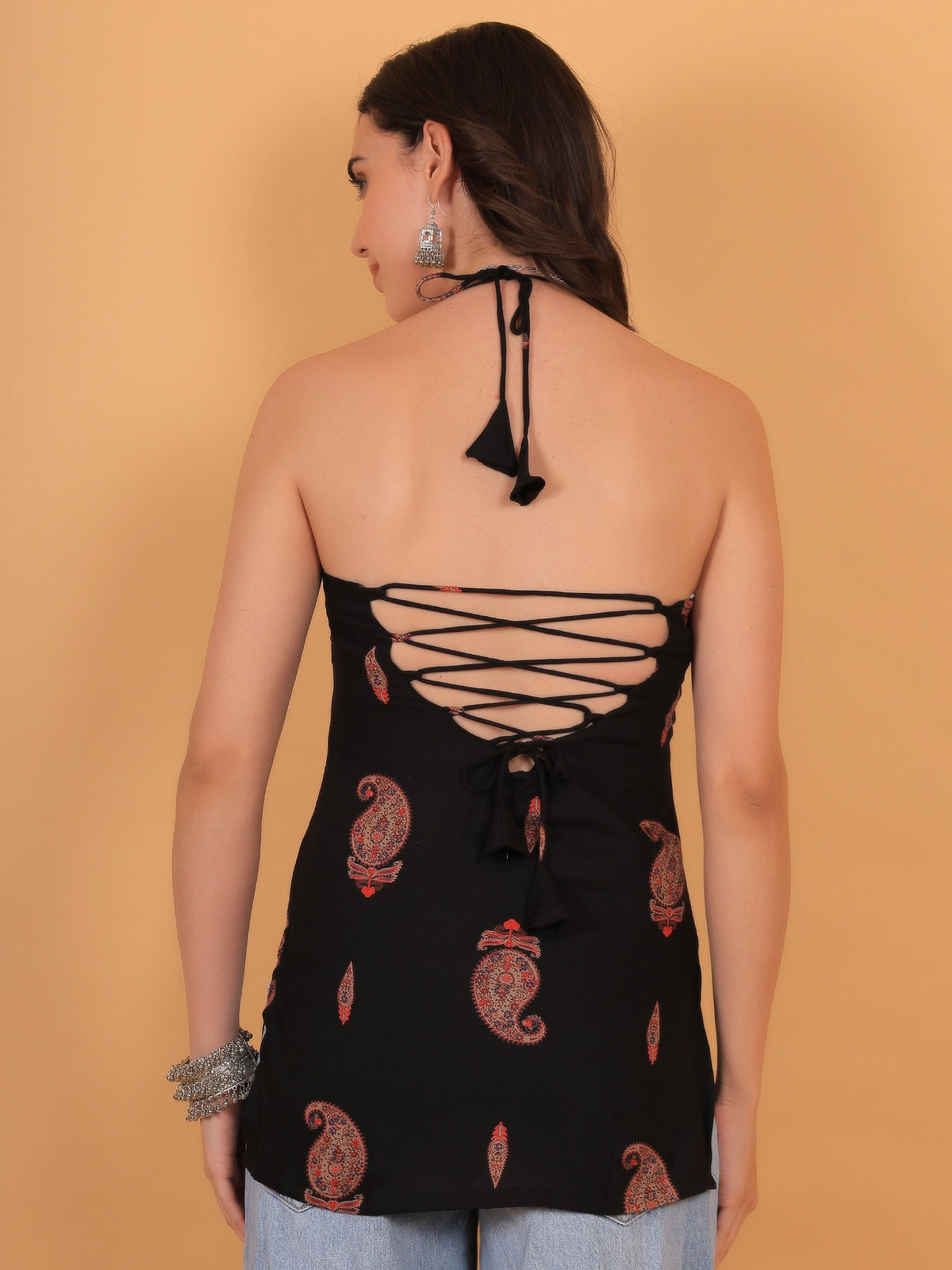 back  close-up view of the Indira black sleeveless kurti, showcasing the delicate halter neckline and traditional red paisley motif print on opaque rayon fabric.