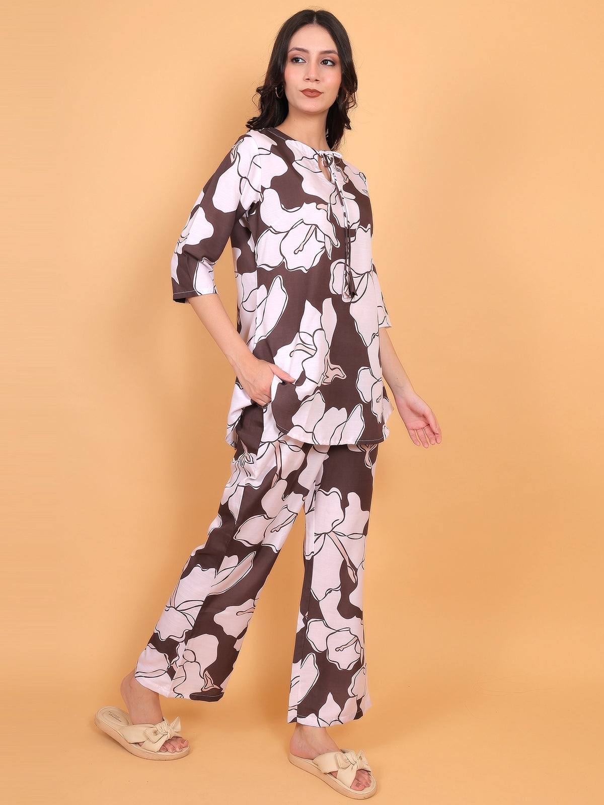 Effortless summer styling of the brown floral matching set paired with a neutral handbag and strappy sandals.