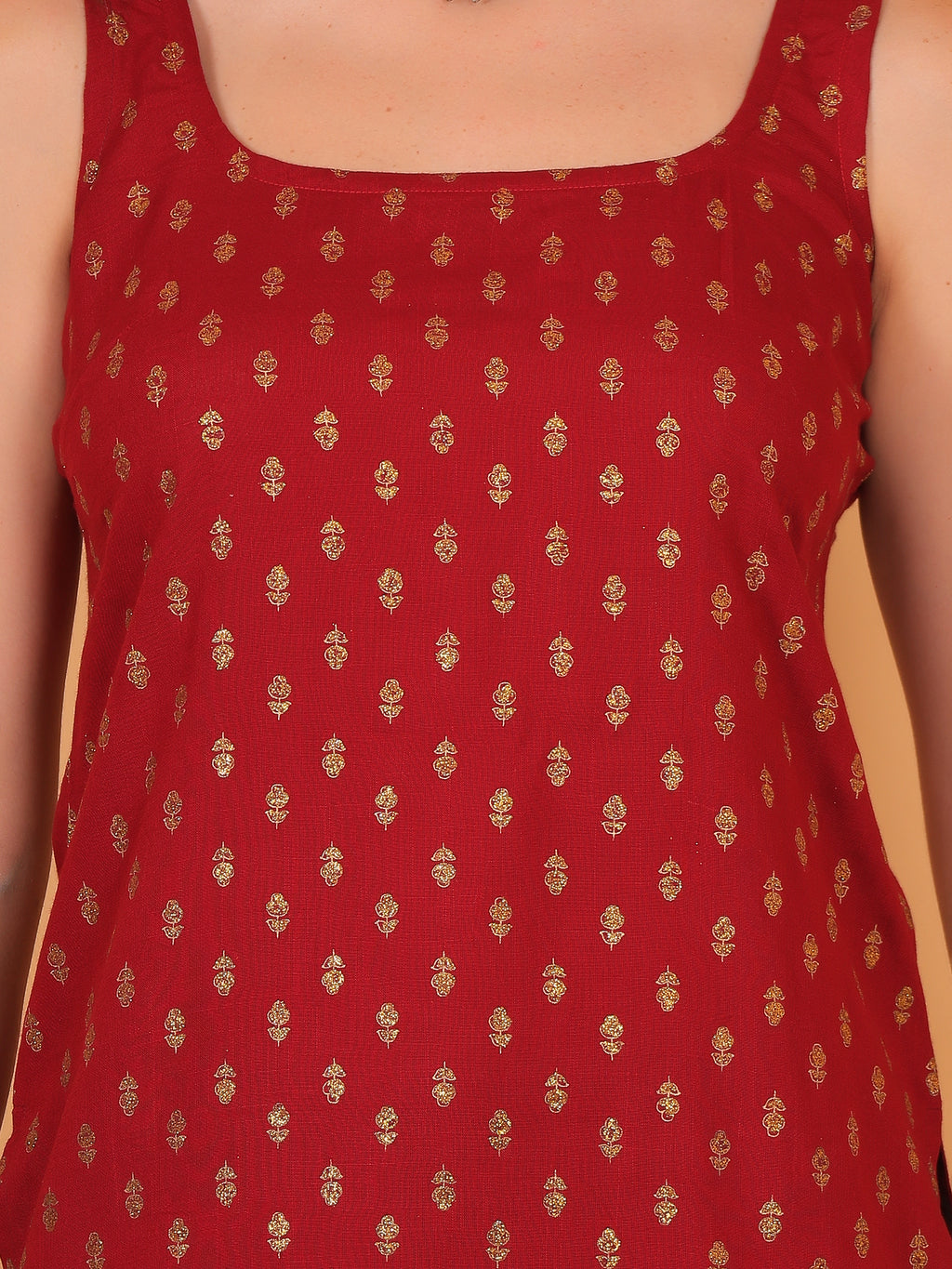 Close up of shiny golden foil texture print on deep red fabric.