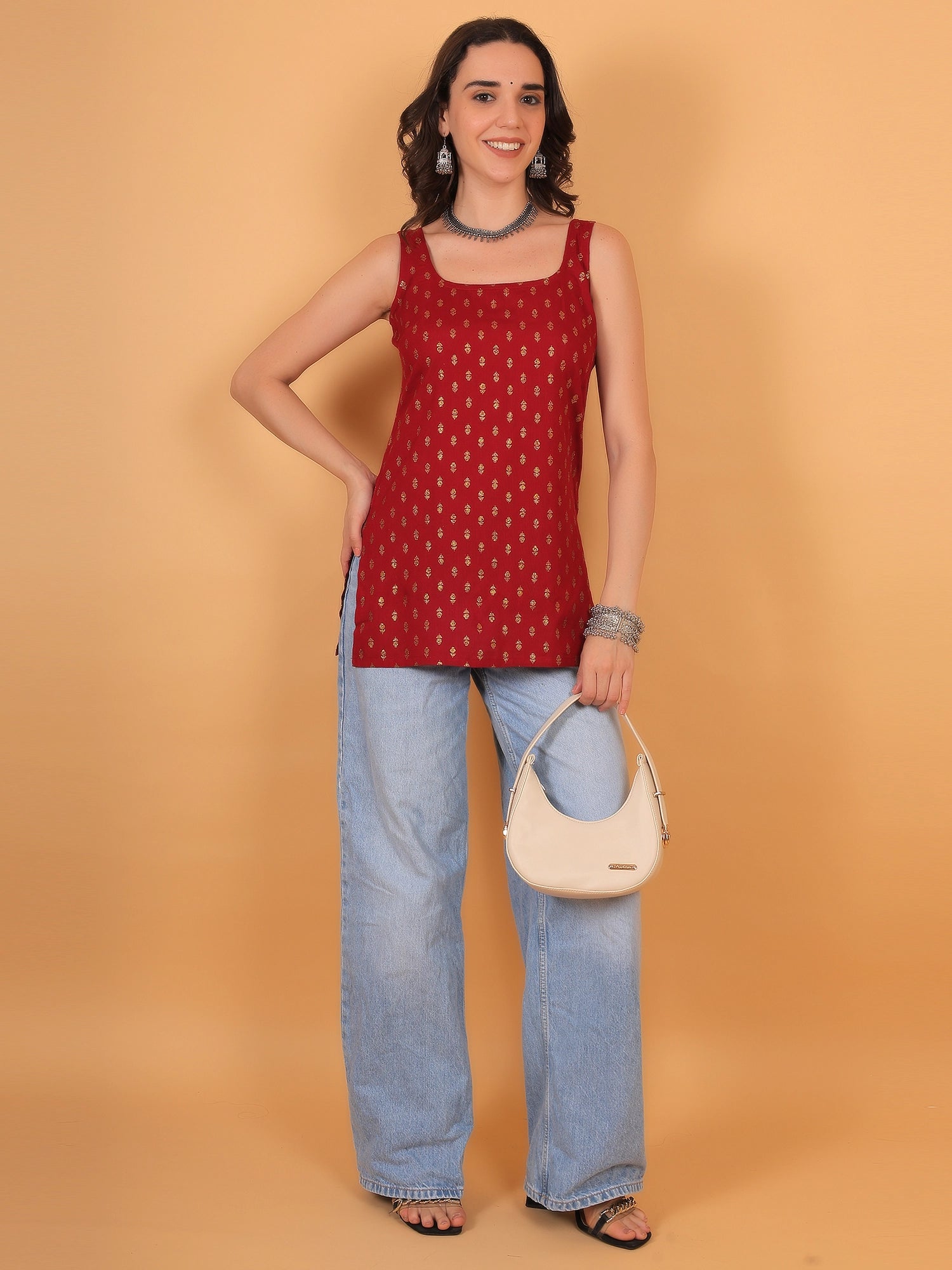 Vibrant red ethnic kurti with gold details paired with denim jeans for a contemporary women's festival outfit