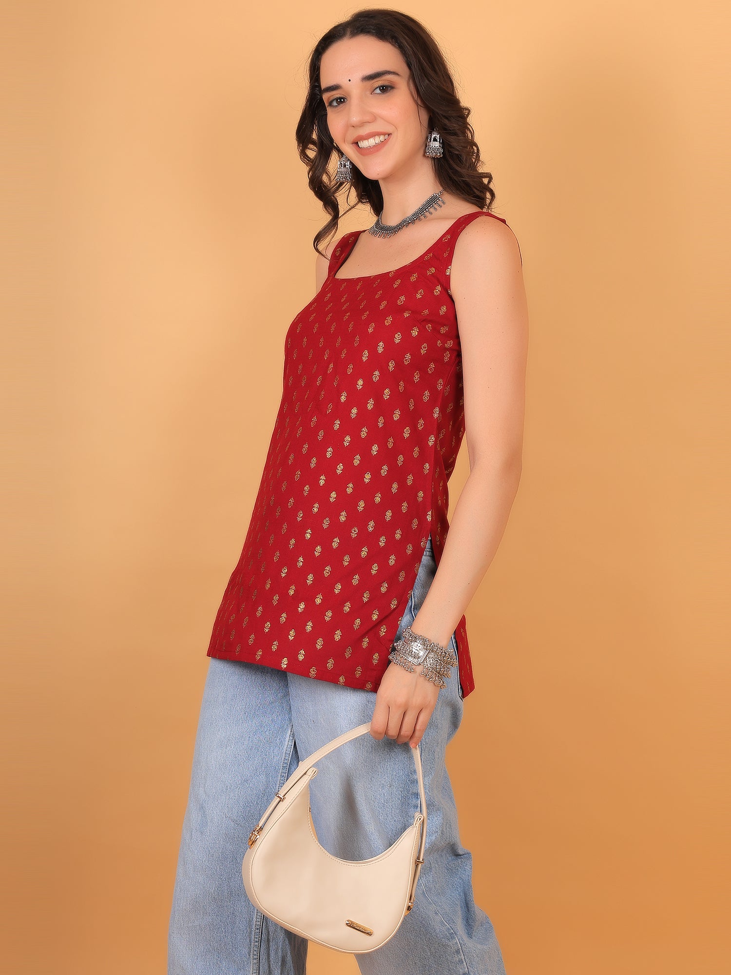Party wear outfit idea: Red sleeveless gold printed kurti with silver jewelry