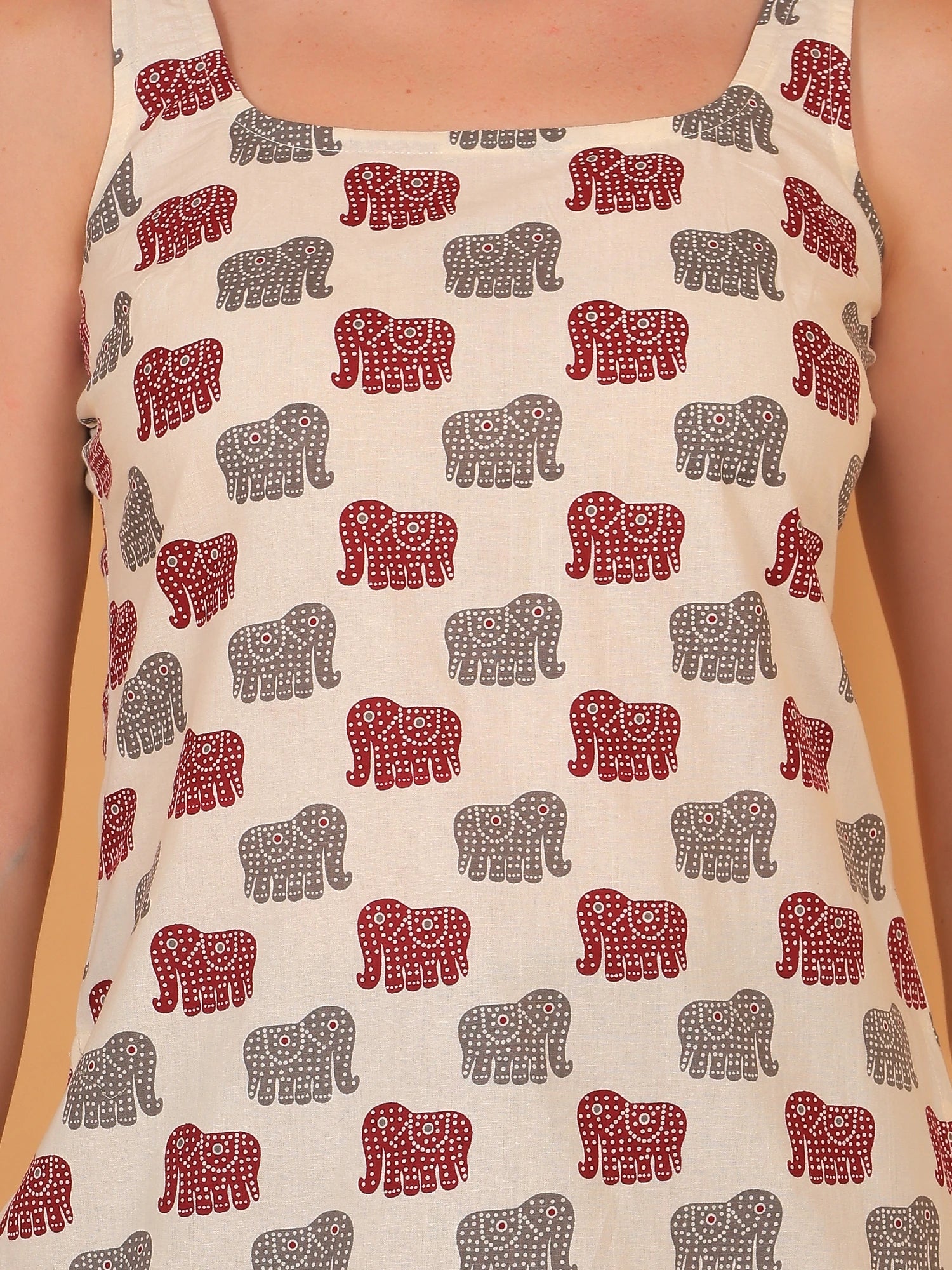 Close-up detail of the breathable rayon fabric and vibrant red traditional animal motifs on the airavat elephant print short kurti.