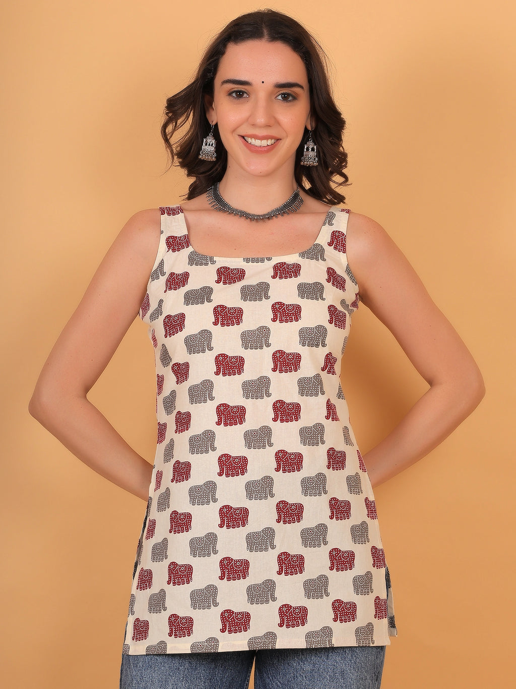 Front view fit inspo of a women cream sleeveless short kurti with a square neckline and an elegant red and grey airavat elephant print pattern.