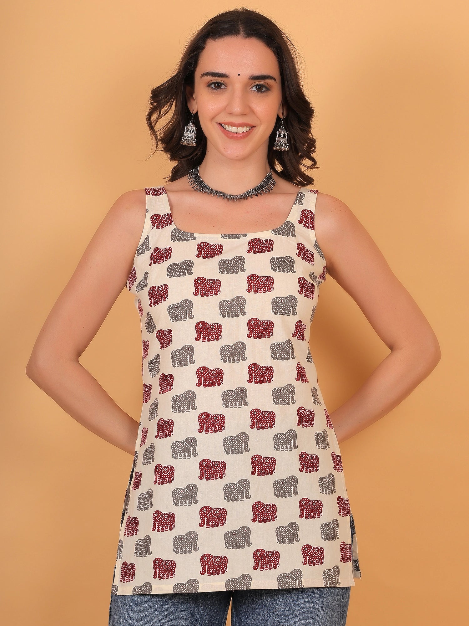 Front view fit inspo of a women cream sleeveless short kurti with a square neckline and an elegant red and grey airavat elephant print pattern.