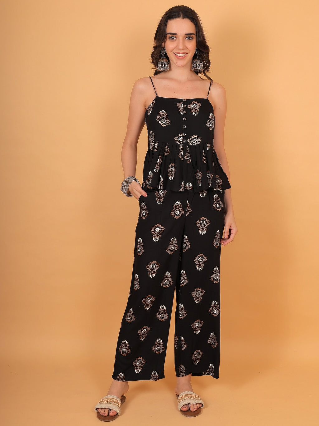 Front view fit inspo of a women black ethnic co ord set featuring a sleeveless strappy peplum top and wide-leg matching top pants ethnic style.