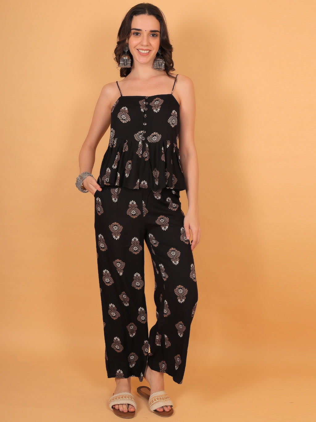 Chic styling shot of a women black sleeveless ethnic co ord set, showing how to dress it up for an elegant date night or festive wear look.