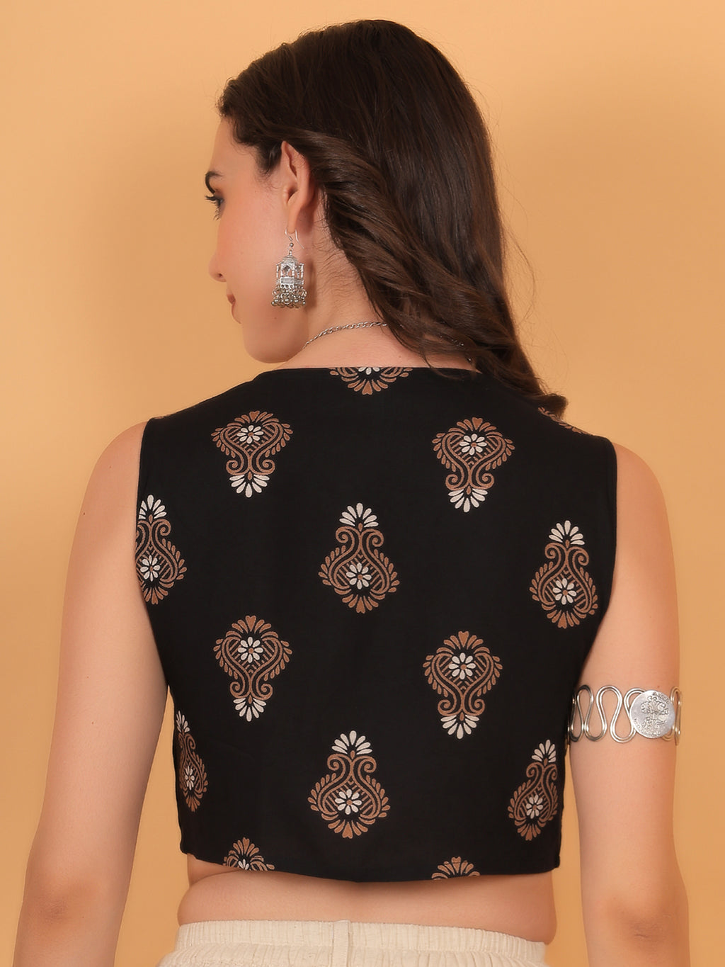 Back view of fitted black sleeveless crop top showing traditional block print motifs.