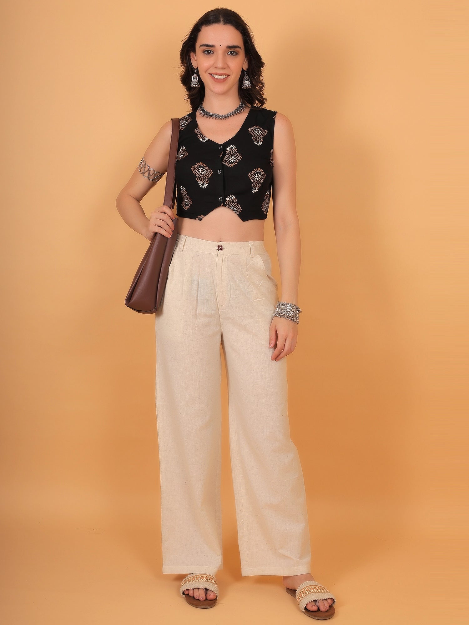 Full-length styling inspiration showing a women black indo western crop top paired with white trousers for a chic casual outing.