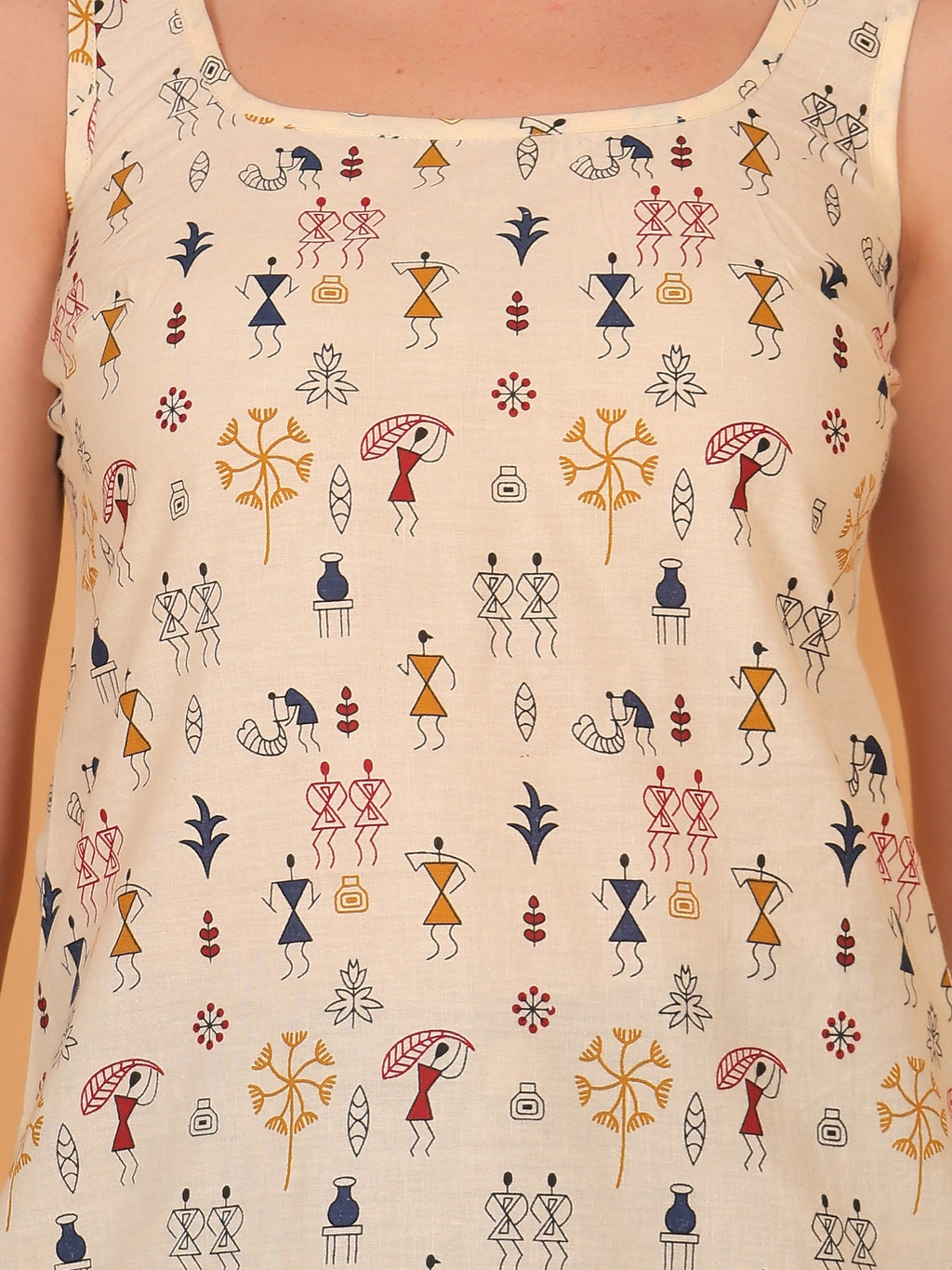 Detailed close-up of the breathable rayon fabric, highlighting the intricate black and red traditional tribal stick-figure warli print on a beige short kurti.