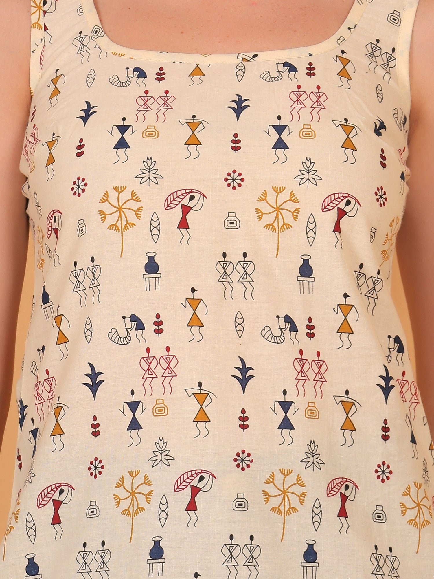 Detailed close-up of the breathable rayon fabric, highlighting the intricate black and red traditional tribal stick-figure warli print on a beige short kurti.