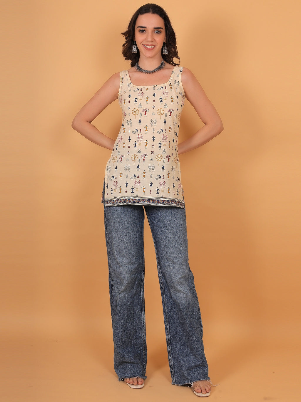 Flattering styling of a women sleeveless ethnic kurti paired with classic blue denim, offering comfortable fit inspo for a casual outing or office wear.
