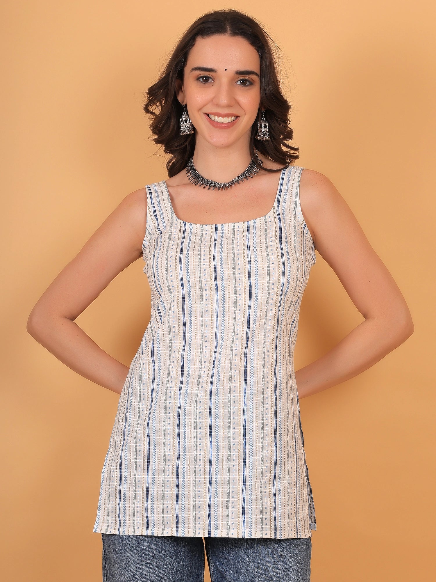 Front view fit inspo of a women white sleeveless kurti featuring a square neckline and vertical blue stripes, styled with a brown tote bag for an elegant look.
