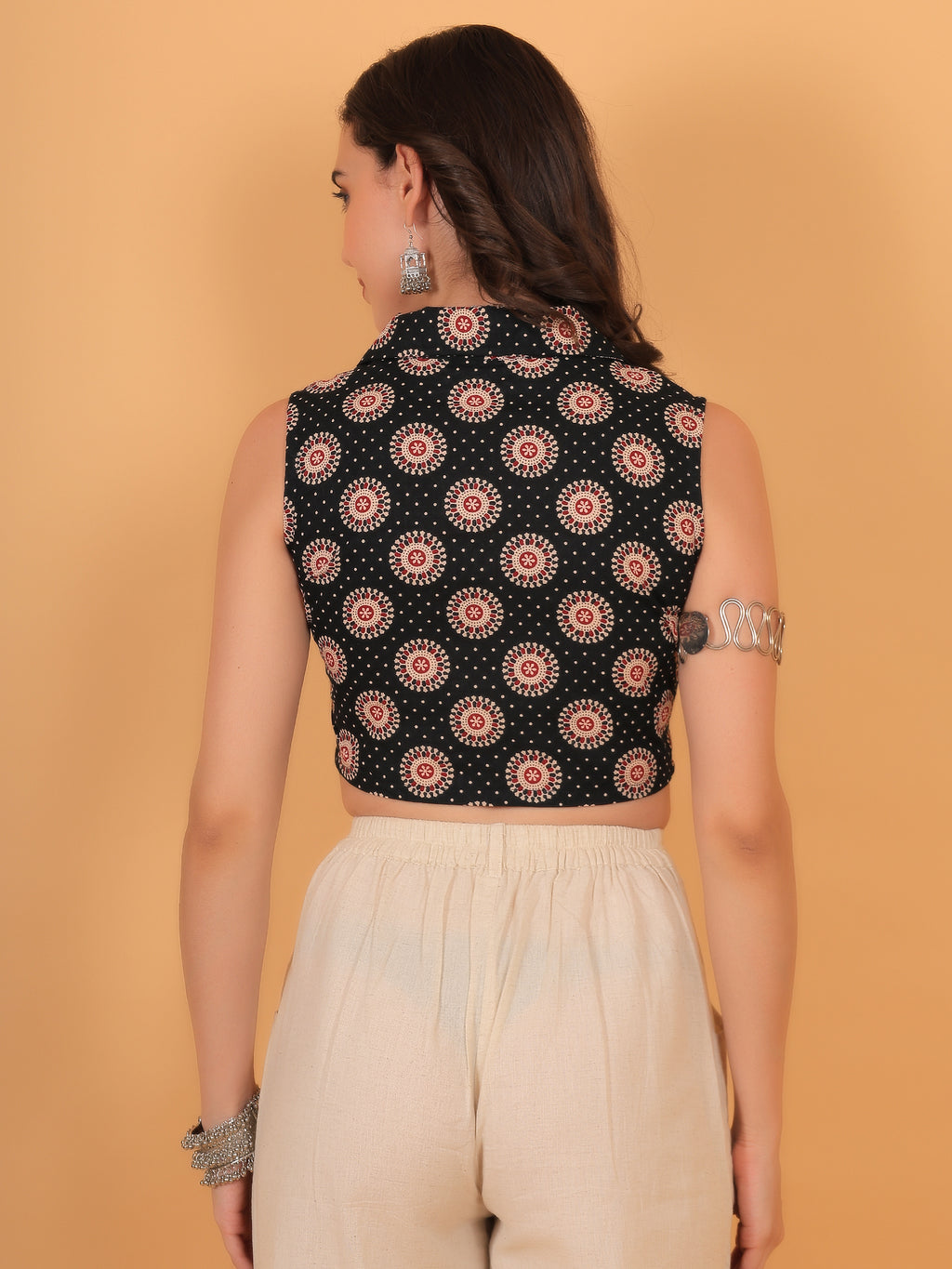 Back view of fitted black sleeveless crop top showing traditional geometric print.