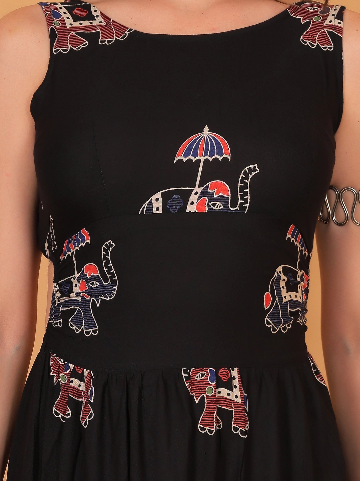 Close-up styling of a women black dress with traditional ethnic prints, showing how to dress it up for an elegant date night or festive wear event.