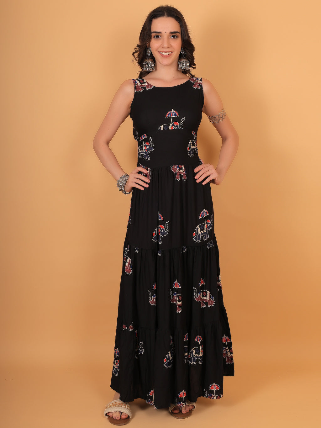 Model posing in Yamini black sleeveless maxi dress with red and blue elephant print.