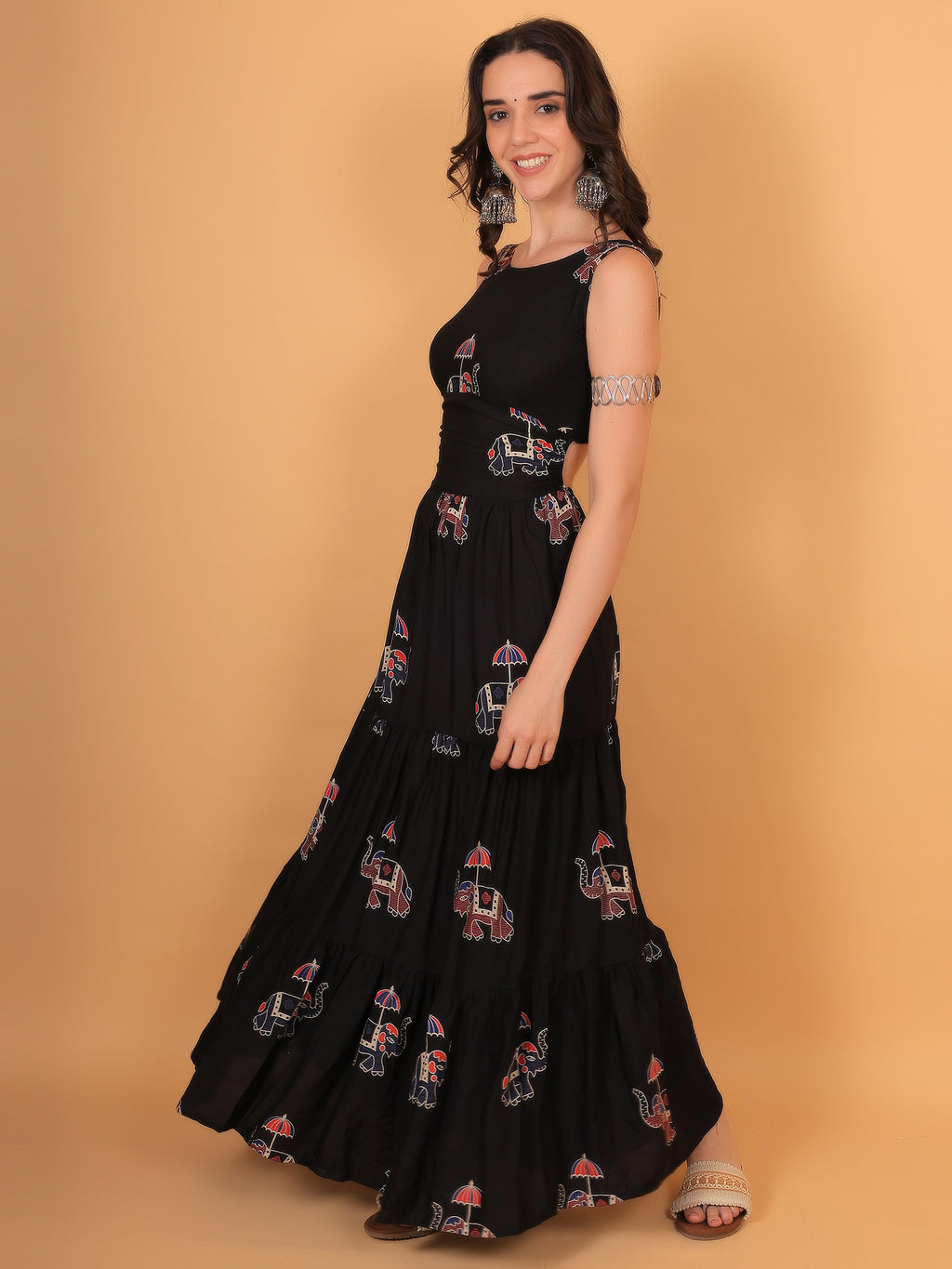 Woman holding flared skirt of black tiered ethnic dress showing volume and flow