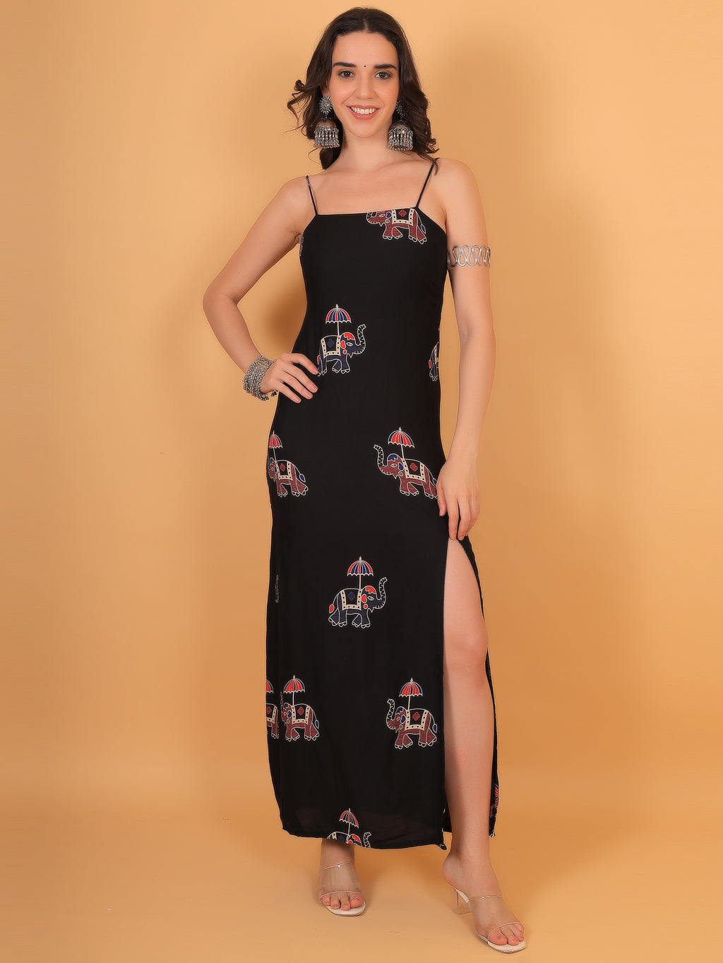 Model posing in gajraaj black spaghetti strap dress with thigh-high side slit