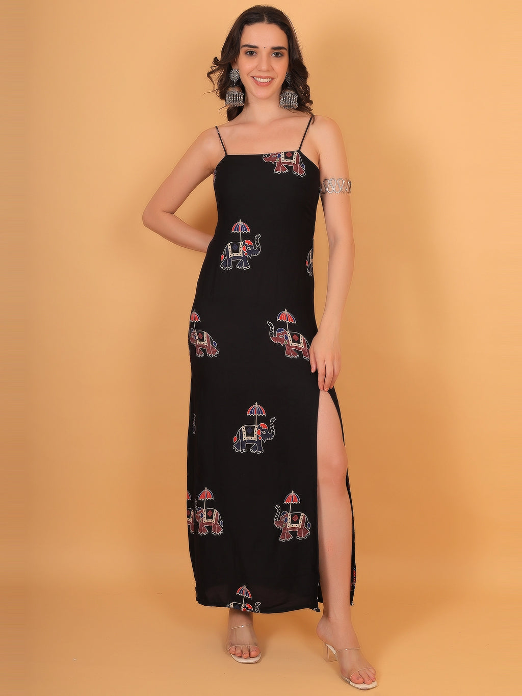Front view fit inspo of a women black dress a-line silhouette, featuring traditional elephant motif prints and a sleek spaghetti strap square neckline.