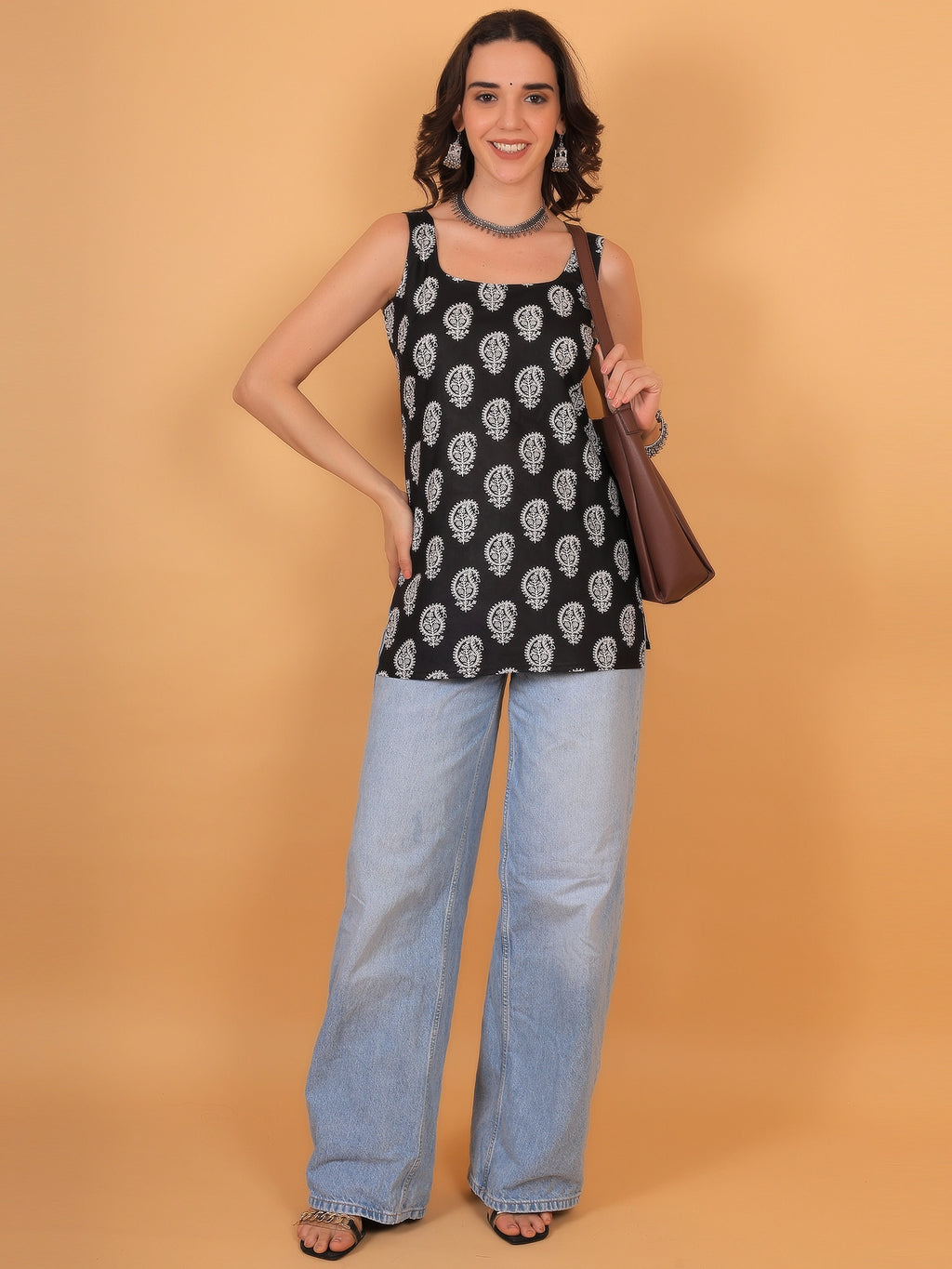 Women's black sleeveless Kaashni printed straight kurti styled with light blue wide leg jeans