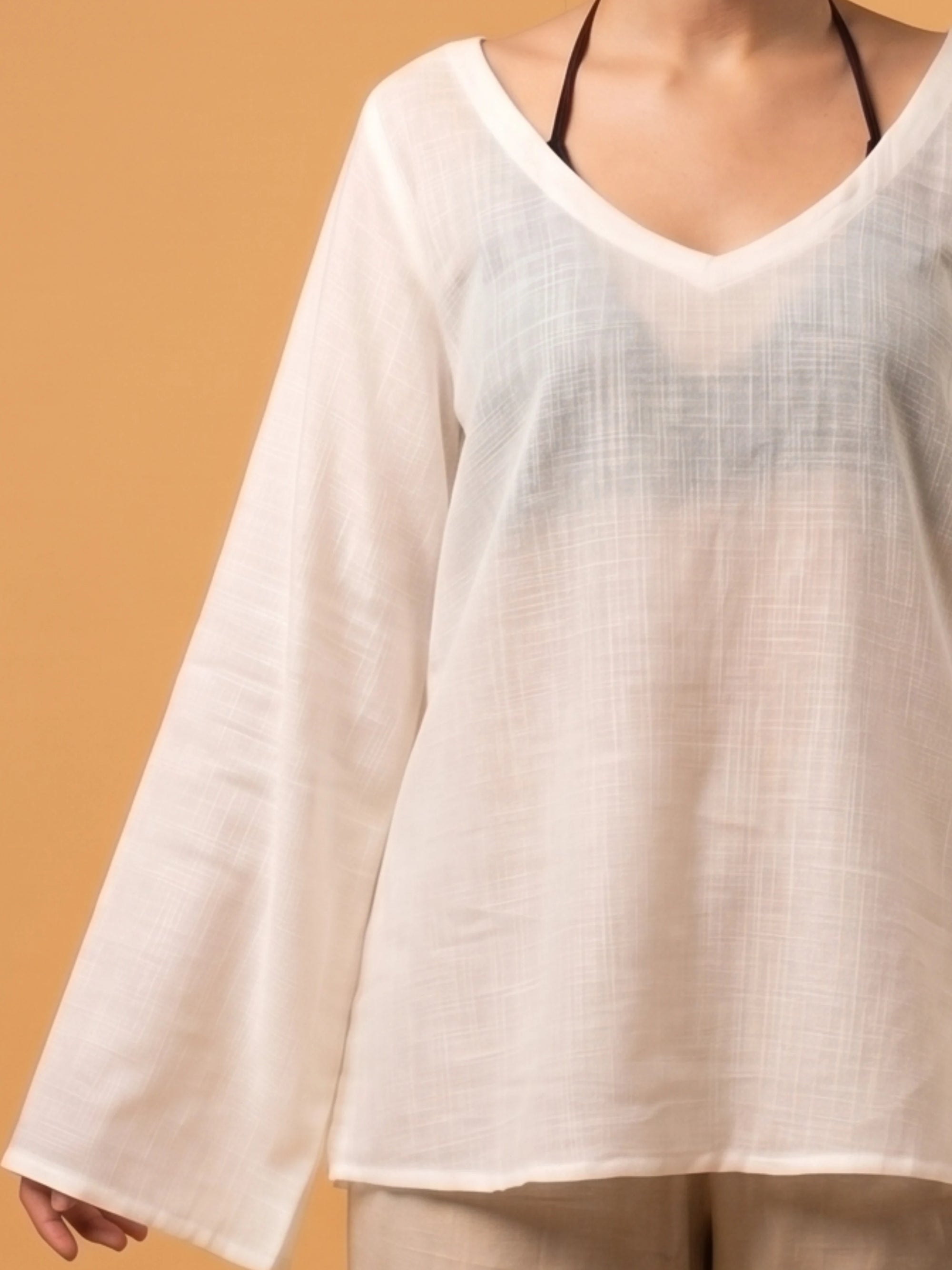 zoom in of the multipurpose Zora sheer cover up displaying its versatile pullover silhouette.