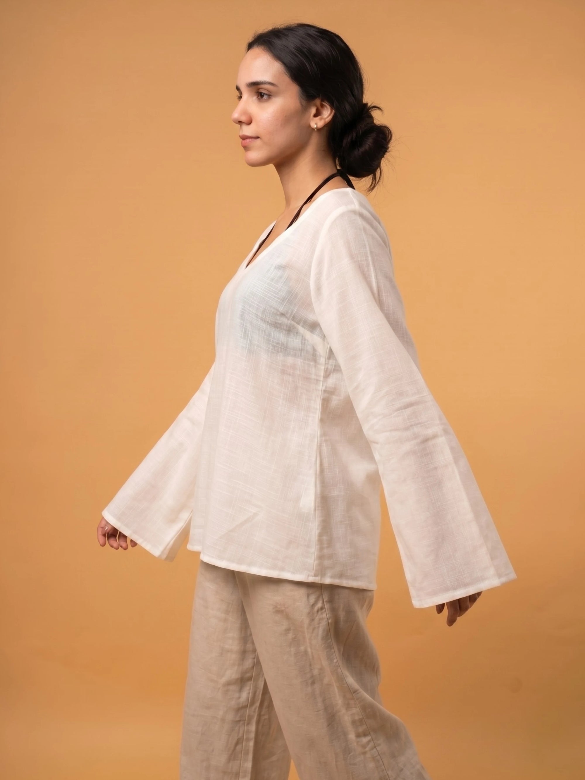 Close-up texture shot of the off-white rayon slub fabric of the Zora sheer translucent coverup top.